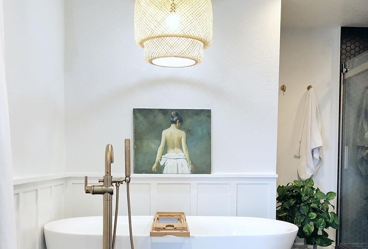 A warm, open bathroom with chandelier lighting