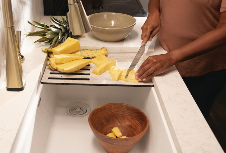 Chopping pineapple at a Workstation sink