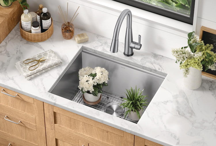 Plants ready to be watered in a Workstation sink