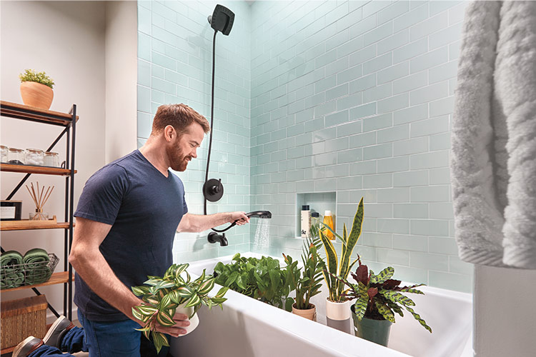 man watering plants in tub using two in one showerhead