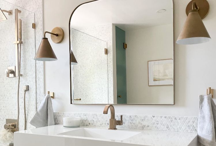 @househomeco's bathroom with gold sconces