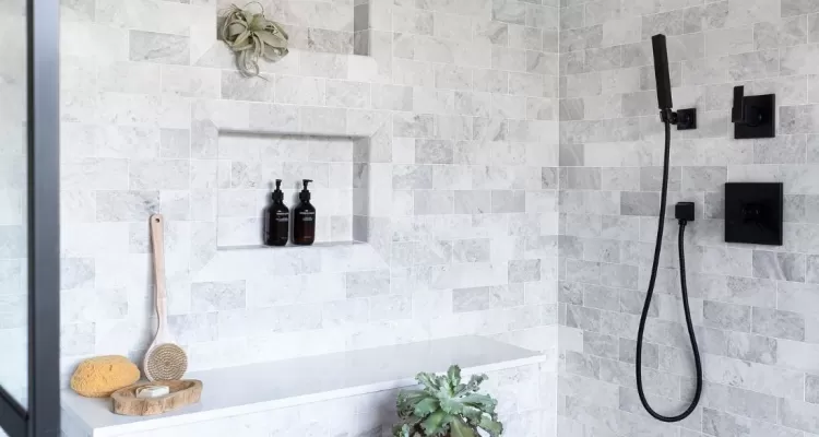 tiled shower with matte black hand shower and fixtures