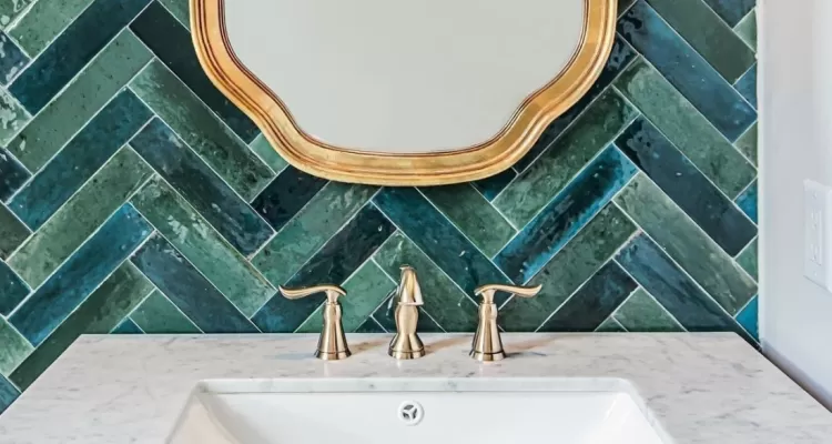green herringbone tile bathroom with gold accents