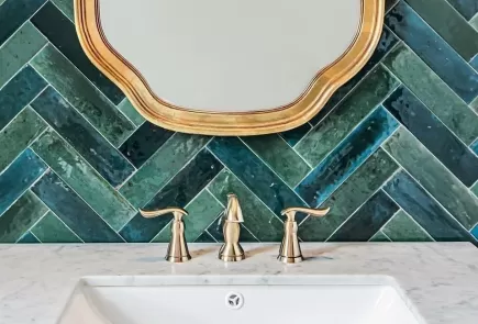 green herringbone tile bathroom with gold accents